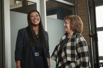 Thuba laughing in conversation with another woman