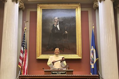 Thuba holding the gavel at Melissa Hortman's Speaker desk.
